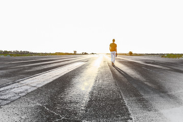 Freedom, airport. A young attractive guy is walking on the runway. 