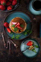 Classic American Breakfast pancake with honey and berries. Still life of lush pancakes, honey and strawberries. Top view