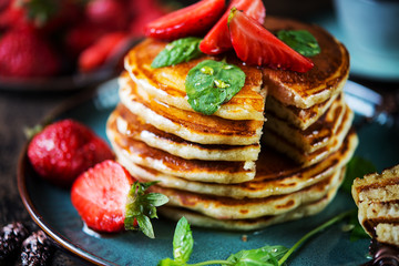 Classic American Breakfast pancake with honey and berries. Still life of lush pancakes, honey and strawberries. Selective focuse