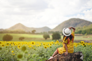 Fototapeta na wymiar asian woman travel at sunflower flower ,Nakhon Ratchasima Province, Thailand