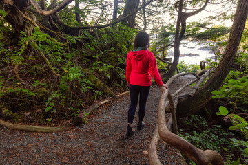 Adventurous Girl walking in a Forest with a beautiful view on the Ocean Coast during a vibrant colorful sunrise. Wild Pacifc Trail, Ucluelet, Vancouver Island, BC, Canada. © edb3_16
