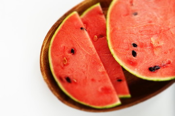 sliced watermelon on wooden plate on white background with copy space