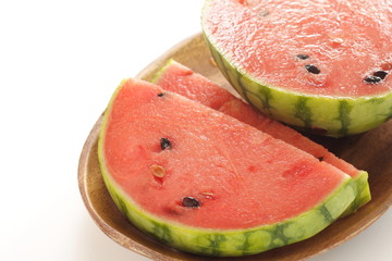 sliced watermelon on wooden plate on white background with copy space