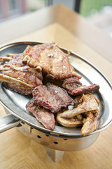 Various grilled meat set heated on coals. Barbecue restaurant menu. Many different food on the table. Dinner party or Banquet