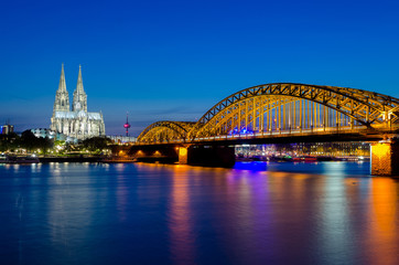 Fototapeta premium Hohenzollern bridge with t Cologne Cathedral and Rhine river during sunset in Cologne, Germany. Europe tourism, history building, or tradition culture and travel concept