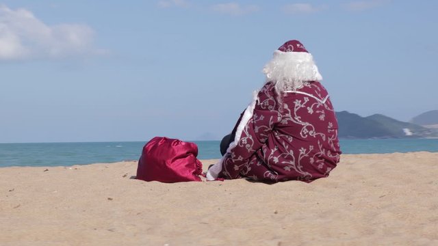 Russian Santa Claus sits on the seashore.