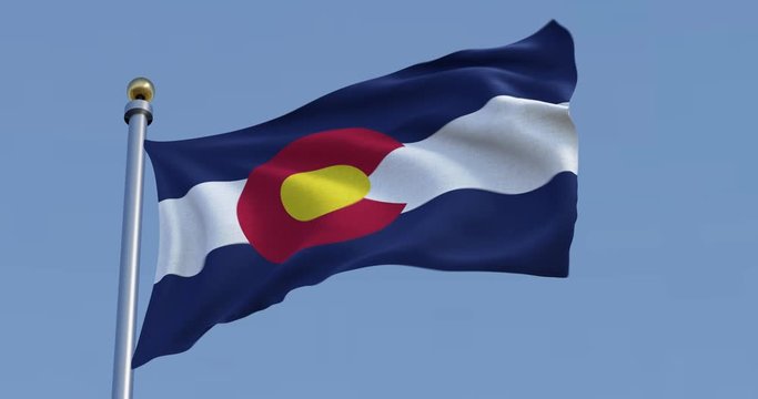  Colorado flag blowing in the wind in front of a blue sky