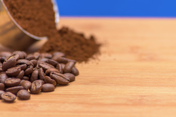 Coffee beans and ground powder on a wooden background. Top view with copy space