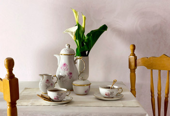 Cups with tea, cookies and a bouquet of callas on the table close-up.