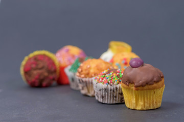 assorted fresh tasty muffins on dark background