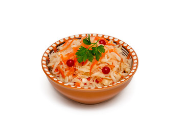 Homemade sauerkraut with carrot in brown clay bowl on white background. Homemade pickles. Fermented food, natural probiotic. Healthy eating and diet concept. Closeup