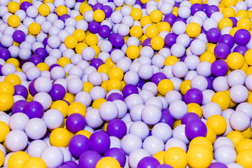 Swimming pool with bright colorful plastic balls on the Playground. White, blue, yellow, red, green balls. Entertaining toys for happy children.