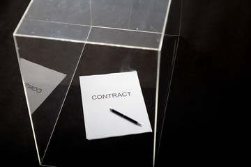 Contract and pen lie in transparent box