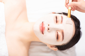 young Woman with mask on face in spa beauty salon