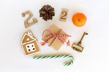 a gift with a house and a golden key, candy staff and New Year 2020. two thousand fir cone twenty mandarin