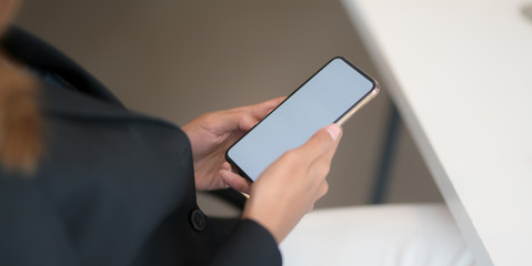 Cropped shot of young businesswoman working with blank smartphone