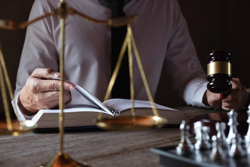 Male lawyer working with lawsuit papers on table in courtroom. justice process and law, attorney, court judge, concept.