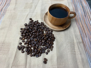 cup of coffee and beans on fabric