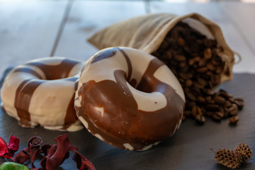 Desayuno con café y donuts sobre plato de pizarra