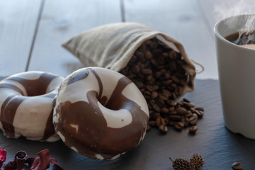 Desayuno con café y donuts sobre plato de pizarra