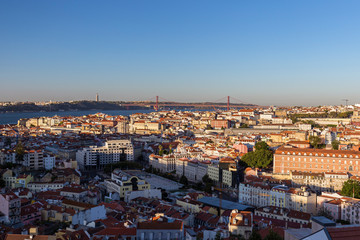 Fototapeta premium Panoramic city view from above of the downtown, 25 de Abril Bridge (Ponte 25 de Abril, 25th of April Bridge) over Tagus River and beyond in Lisbon, Portugal.
