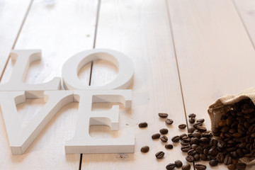 Palabra LOVE con café sobre tablas blancas