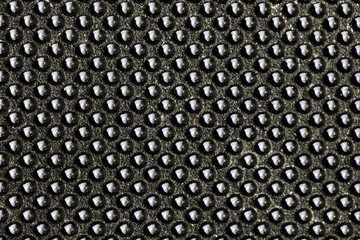 Black bumpy rubber surface used as a background. Black and white texture of rubber material with copy space. Bubble dots background pattern. Studio macro photography.