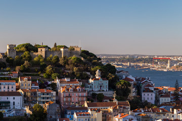 Scenic view of the Sao Jorge Castle (Saint George Castle, Castelo de Sao Jorge) and old buildings at the Alfama district in downtown Lisbon, Portugal.