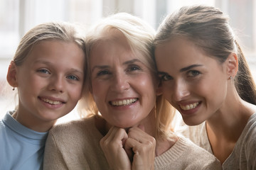 Portrait of three generations of women posing at home