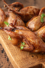 Delicious fried roasted quails with herbs, spices and beer. Grilled quails. Holiday Christmas and Thanksgiving meal concept.