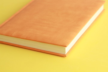 Fototapeta premium book with orange cover on colorful background