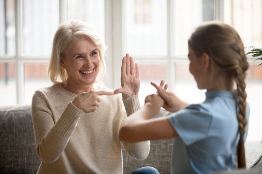 Disabled grandmother and granddaughter talk using sign language
