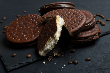 Closeup of cracked chocolate biscuits with coffee taste on the black table