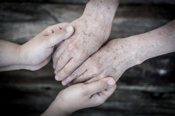 Fototapeta premium Young and old hands love and care