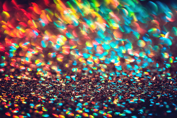 Multicolor blurred neon lights star flares and rainbow glitter on dark background. Bokeh lens flare...