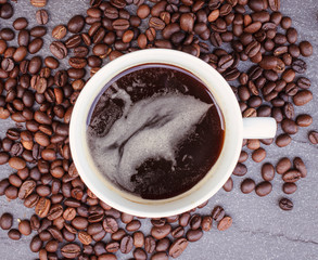 Top view mockup a cup of coffee and coffee beans on the black stone.