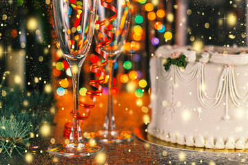 Christmas and New Year celebration concept. Champagne, glasses and holiday cake near the Christmas tree with decorations.