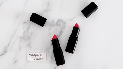 two identhical looking lipsticks and hand placing Original Product and Product Dupe labels
