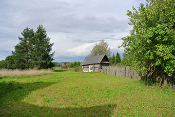 Obraz premium small rural bath next to the garden and field