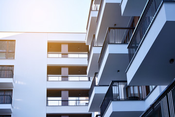 Sun rays light effects on urban buildings. Fragment of modern residential apartment with flat buildings exterior. Detail of new luxury house and home complex. 