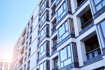 Sun rays light effects on urban buildings. Fragment of modern residential apartment with flat buildings exterior. Detail of new luxury house and home complex. 