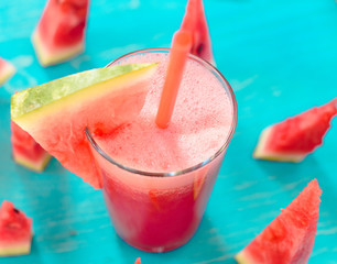 smoothie with watermelon on a turquoise background in a glass with a slice of watermelon with copy space