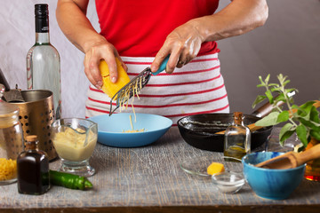 chef rubs the cheese on a grater. Authentic cooking