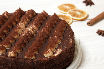 DeliciousTiramisu cake close-up on a white wooden background.