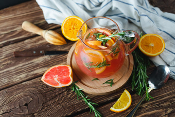 Fresh summer lemonade with grapefruit and rosemary on an old wooden table. Summer concept.