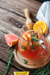 Fresh summer lemonade with grapefruit and rosemary on an old wooden table. Summer concept.