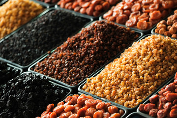 A pile of raisins, various types of dried fruits and other organic products on the counter of the store.