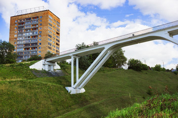 Pedestrian bridge of concrete across deep ravine in the city