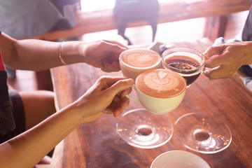 Business coffee break after success discussion cheers the cup of coffee.Friendship meeting in weekend at coffee shop.People hand holding coffee cup and cheers for agreement after negotiation.