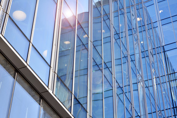 Sun rays light effects on urban buildings. Modern office building detail, glass surface with sunlight. Business background. 